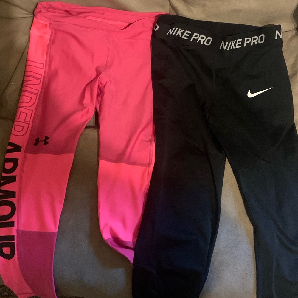 Two pairs of girls leggings. Pink are size medium. Black are large.